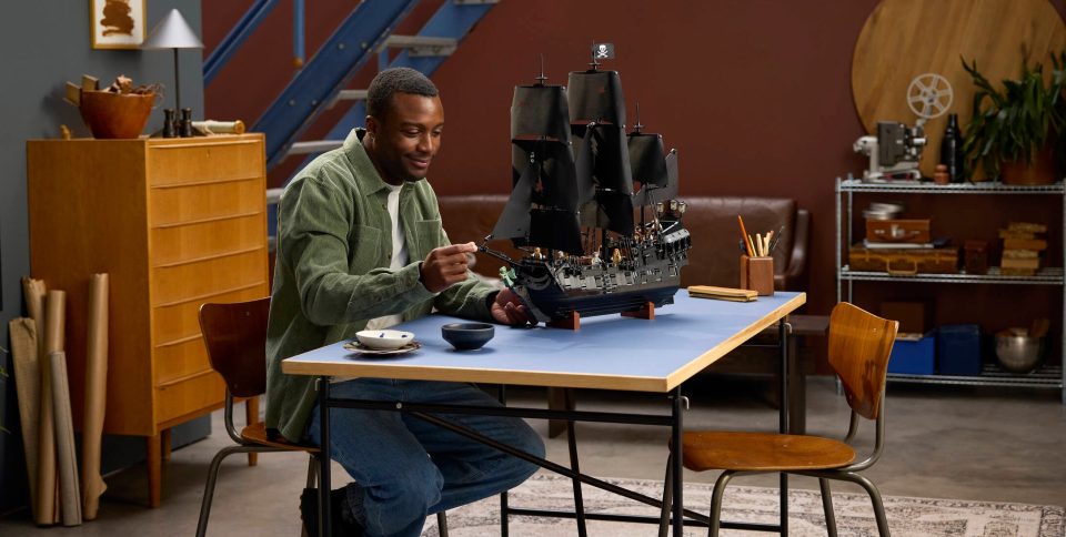 Click here to enlarge image Man sitting at table holding 10365 Jack Sparrow's Pirate Ship