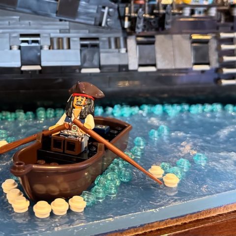 Jack Sparrow in boat rowing towards LEGO Icons 10365 Black Pearl