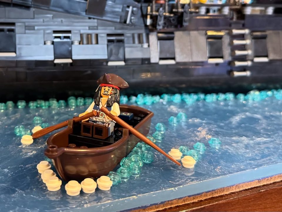 Jack Sparrow in boat rowing towards LEGO Icons 10365 Black Pearl