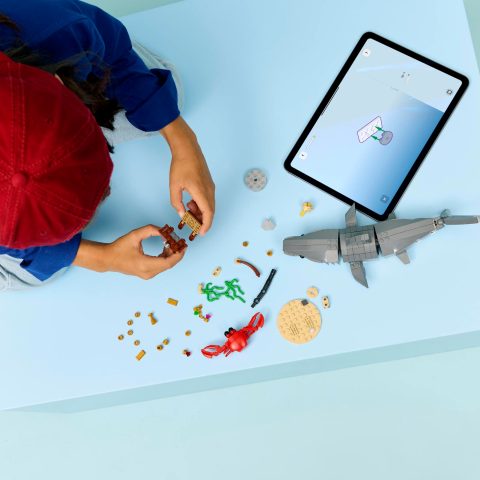 Child using LEGO Builder Mobile App to construct 31381 Fierce Shark with a Treasure Chest