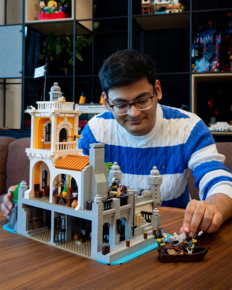 Man positioning a minifigure at rear of Coconut Cape
